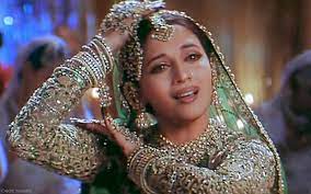 Madhuri Dixit posing with a smile, holding an award.