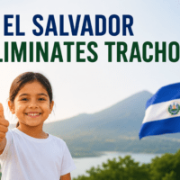 Smiling child with the El Salvador flag celebrating the elimination of trachoma.
