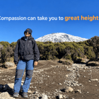 Ananya Jain standing on Mount Kilimanjaro with a snow-covered peak in the background.